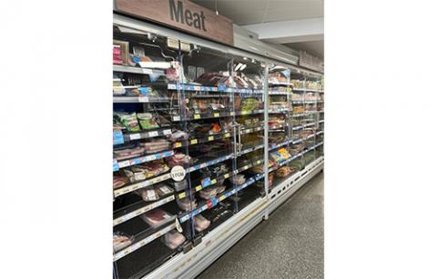 A picture of open chillers displayed in a convenience store stocked with meat items for purchase