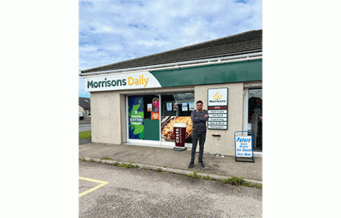 Man standing outside Morrisons Daily smiling with arms crossed