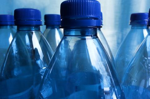 Close up image of six blue plastic water bottles