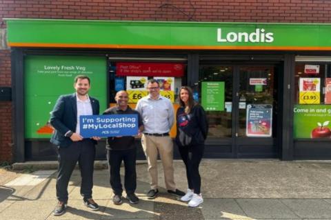 Four people standing in front of a shop.